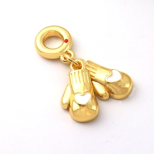 Dettaglio macro di ciondoli a guanto placcati oro 18k con cuori bianchi per bracciali