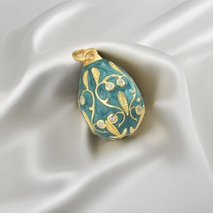 Macro shot of Fabergé style turquoise enamel egg pendant with gold vine and crystals