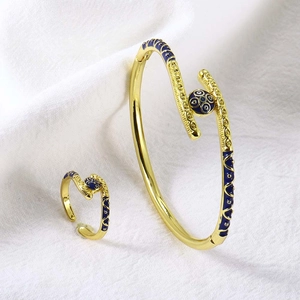 Detail van de 18k vergulde sieradenset met blauw emaille en gouden spiraalpatronen
