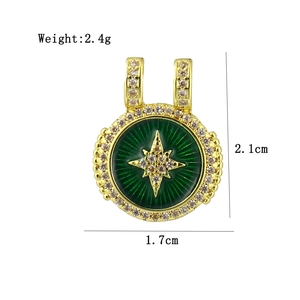 Macro detail of a 18K gold-plated starburst charm with green enamel and zircons
