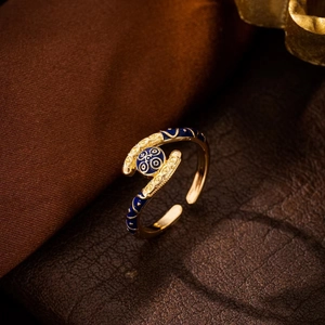 Macro-opname van een vergulde verstelbare ring met blauw emaille golfpatroon in vintage stijl