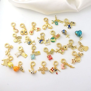 Dettaglio di ciondoli smaltati placcati in oro 18k con temi viaggio e sport per braccialetti