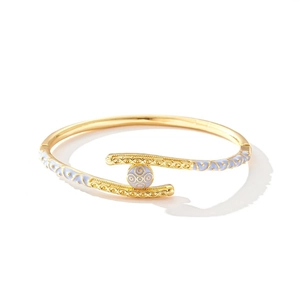 Detail van een 18k vergulde armband met blauw emaille en retro reliëfpatronen in goud