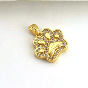 Dettaglio di un ciondolo a zampa placcato in oro con micro-intarsio in zircone bianco