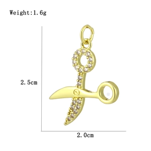 Detailed view of gold scissor pendant with cubic zirconia, size 2.5cm by 2.0cm
