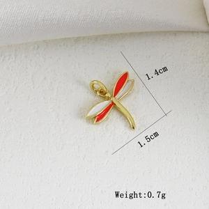 Vista macro del ciondolo a libellula in smalto rosso e bianco con anello per gioielli