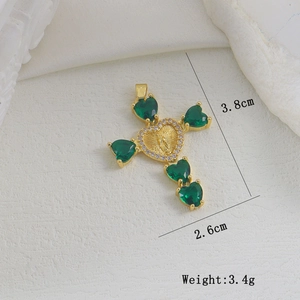 Macro-detail van 18k vergulde kruishanger met groene hartstenen en Maria-reliëf