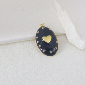 Makroaufnahme von ovalem schwarzem Emaille-Anhänger mit Goldherz und Zirkonia