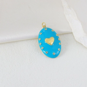 Detail eines blauen Emaille-Anhängers mit goldenem Herz und Zirkon-Akzenten auf Seide