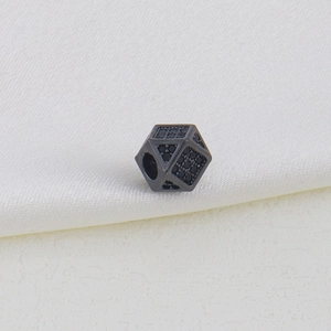 Macro shot of geometric black faceted bead with micro-pave zircons and center hole