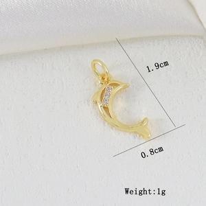 Dettaglio ciondolo a delfino dorato con zirconi e dimensioni di 1,9cm x 0,8cm