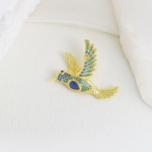Exquisite hummingbird pendant encrusted with colorful cubic zirconia on a white background