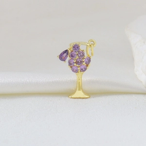 Dettaglio del ciondolo a calice in metallo dorato con zirconi viola a forma di uva