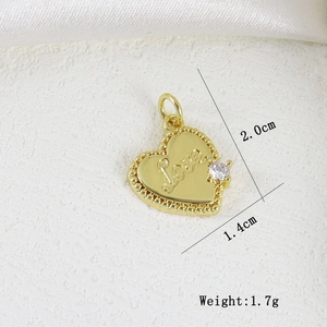 Detail view of a 2.0cm gold heart pendant with Love engraving and zircon stone inlay