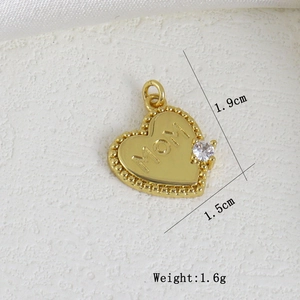 Detail view of heart-shaped gold charm with MOM engraving and zircon stone inlay