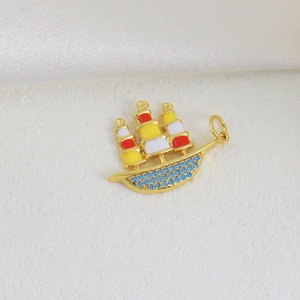 Goldener Segelboot-Anhänger mit bunten Emaille-Segeln und blauen Kristallakzenten