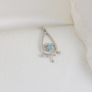 Silberner Evil Eye Anhänger mit blauem Opalstein und Zirkon auf Steinhintergrund