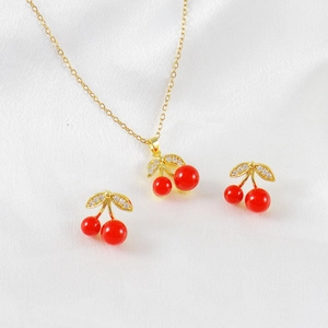 Elegant cherry jewelry set with red pendant necklace and zircon stud earrings on silk