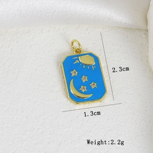 Detail of blue enamel moon and sun pendant with dimensions 2.3cm by 1.3cm