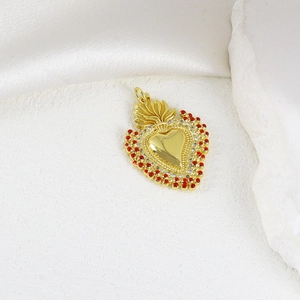 Gold sacred heart pendant with red and white cubic zirconia on elegant satin background