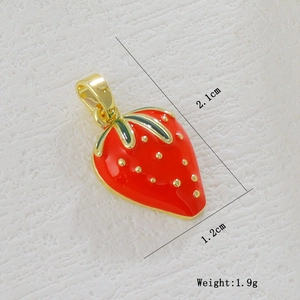 Close-up of a gold-plated strawberry pendant with red enamel and green leaf detail