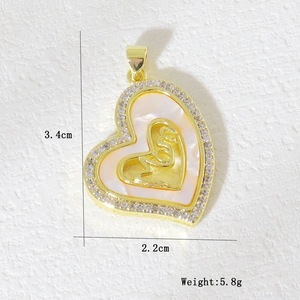 Detail of gold heart pendant with Mom text, white shell inlay, and zircon stones