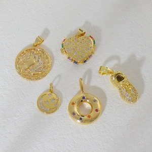 Dettaglio di ciondoli placcati in oro 18k con unicorno, cuore e motivi a stella