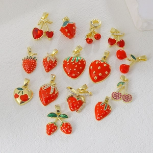 Detailed view of red strawberry and cherry charms with gold plating and zircon inlay