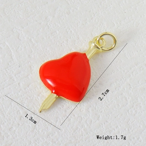 Macro detail of red heart pendant with gold arrow and precise size measurements