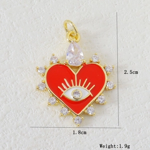Macro detail of gold heart evil eye pendant with red enamel and white zircon stones