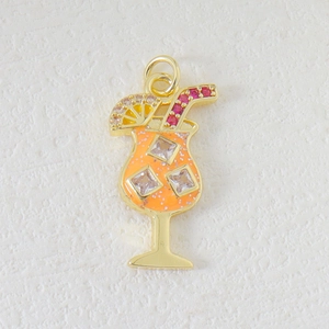 Detail of luxury cocktail pendant with orange enamel and zircon stones in gold plating