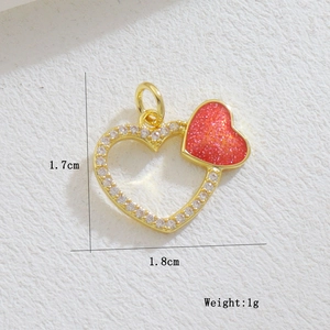 Detailed view of gold plated heart pendant with red enamel and pavé zircon settings