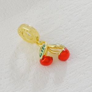 Macro detail of gold-plated cherry pendant with red zircon and S925 hallmark