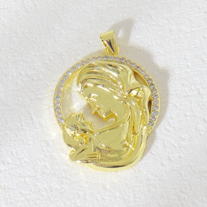 Detailed view of oval gold-plated pendant with mother and child relief and zircon stones