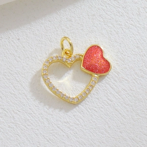 Detail of gold-plated double heart pendant with pavé crystals and red glitter inlay