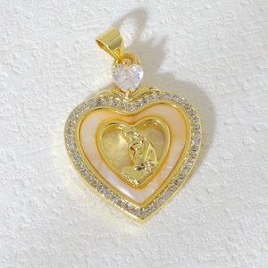 Detailed view of heart-shaped gold pendant with mother of pearl and religious relief