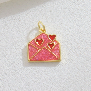Detailed view of pink glitter envelope pendant with red hearts and gold plating