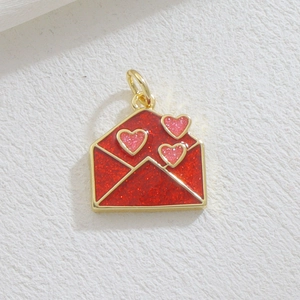 Macro detail of a red gold-plated envelope pendant with pink glitter hearts for DIY jewelry
