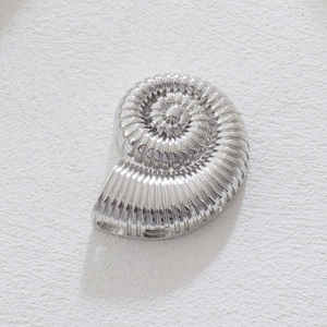 Dettaglio del ciondolo a conchiglia d'argento lucido con trame metalliche chiare