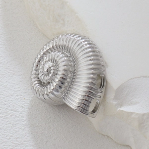 Macro di un ciondolo a forma di conchiglia argentata con dettagli per gioielli fai-da-te