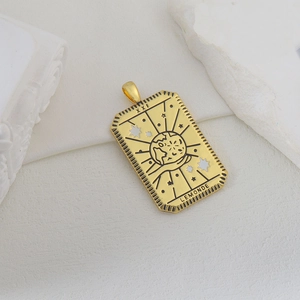 Detalle del colgante de tarot bañado en oro con el diseño de El Mundo XXI y grabado fino