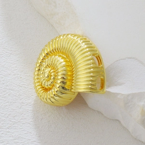 Vista macro di un ciondolo a forma di nautilus dorato con eleganti trame a spirale