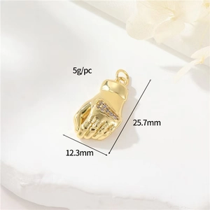 Macro detail of 18k gold plated fist pendant with sparkling zircon stone setting