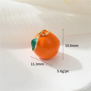 Macro view of gold-plated orange charm with dimensions showing 15.9mm height and 11.3mm width