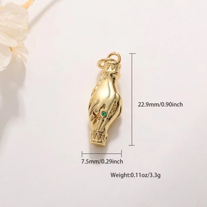 Detail of gold hand charm with green gemstone including dimensions 22.9mm and 3.3g weight