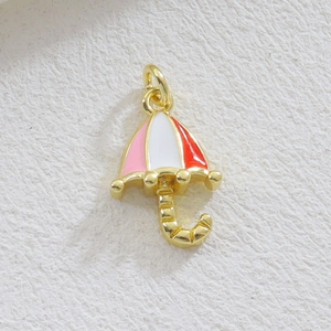 Vue macro d'un pendentif parapluie en émail coloré avec plaquage or et anneau