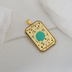Colgante tarot sol dorado con esmalte verde y grabado Le Soleil sobre piedra blanca