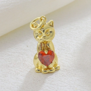 Dettaglio di un ciondolo a forma di gatto dorato con zircone rosso a cuore