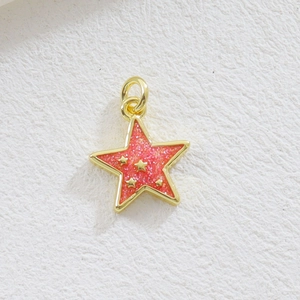 Vue détaillée du pendentif étoile dorée avec résine rouge pailletée et petites étoiles