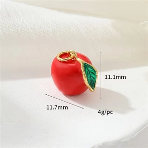 Macro detail of red apple charm with green leaf and dimensions showing size and weight